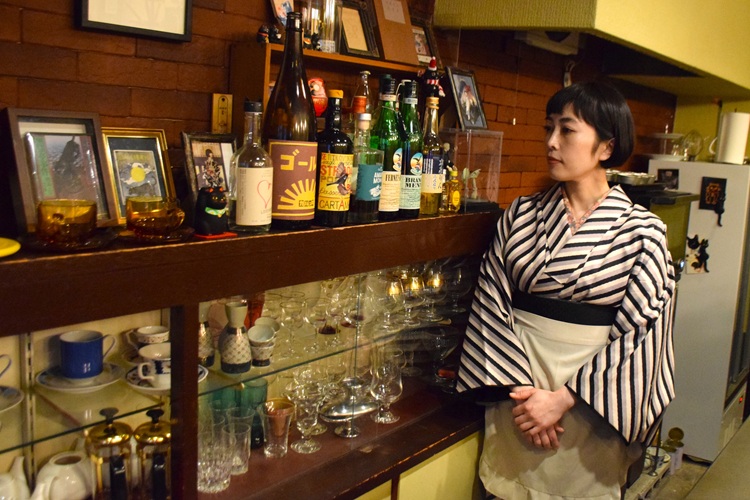 お気に入りの食器や小物が飾られた棚の前で、お客様への思いを語る宇都木さん