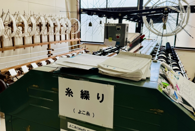 染め上がった絹糸を使いやすい形に巻き直す工程「糸繰（いとく）り」