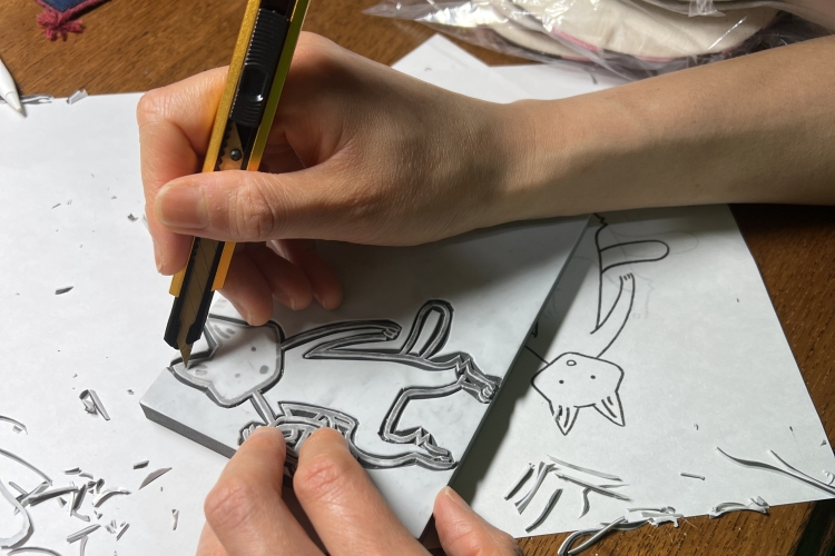 イラストに沿って消しゴムはんこをカッターで削り、絵柄の版をつくる